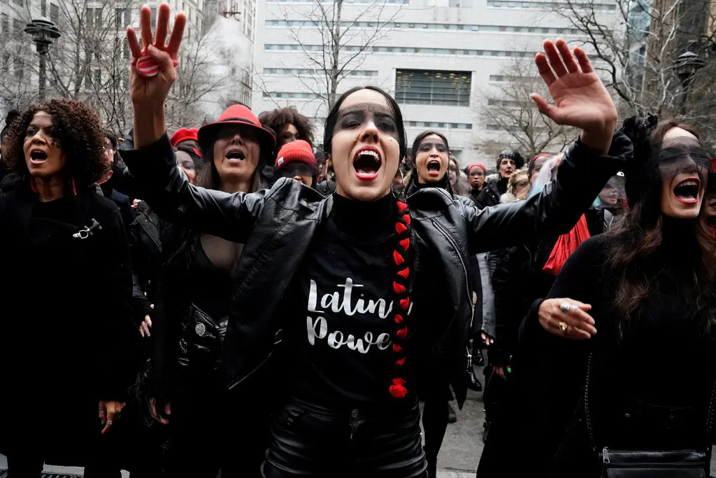 women dressed in black appear to be yelling standing together in a city