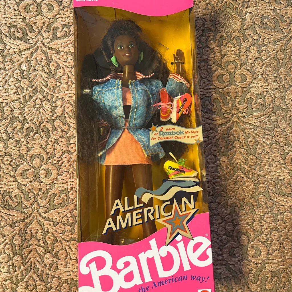 Image of 1990 All-American African American Barbie in box. She has short orange dress and jean jacket on