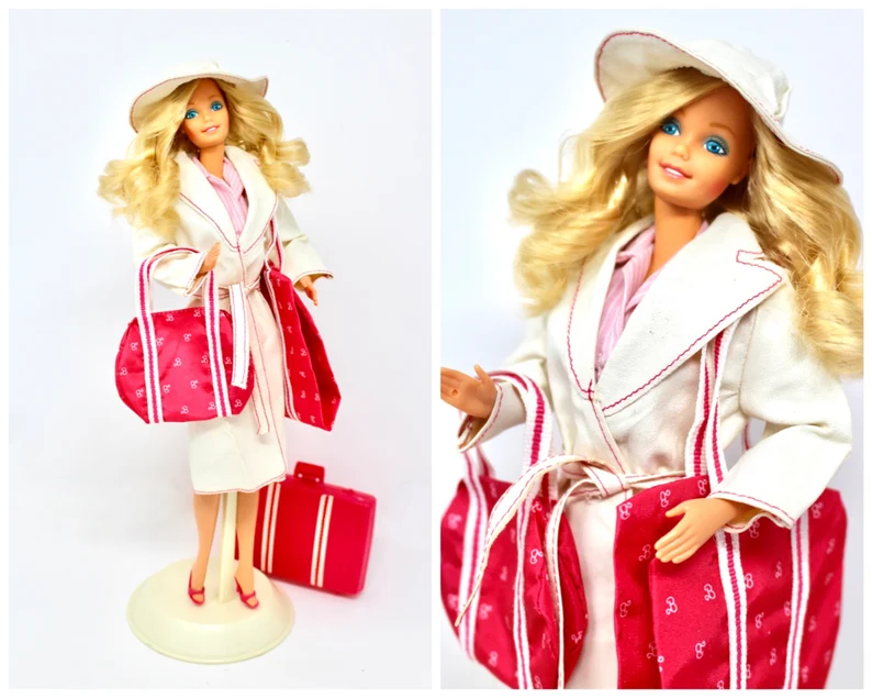 Image of white blond Barbie with luggage set in hat and trenchcoat