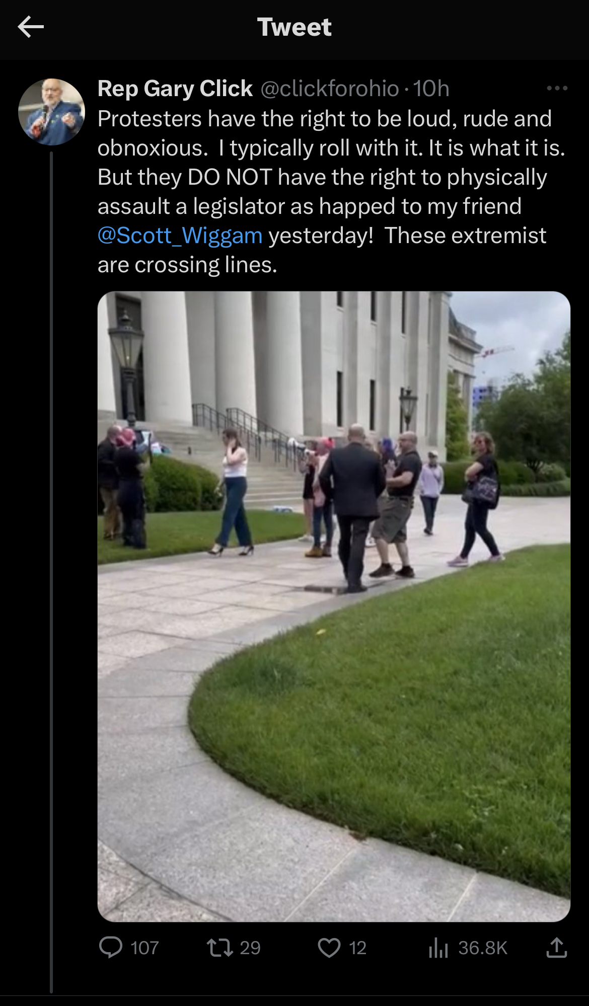 Twitter handle at click for ohio posting publicly and lying publicly, claiming trans rights activists are harming people when State Rep Stott Wiggam pushes a protestor intentionally by the looks of the video.