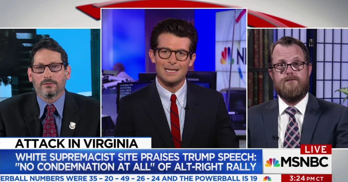 Screencap of MSNBC News anchor in black suit jacket with red tie and glasses, interviewing two men about a white supremacist website. 